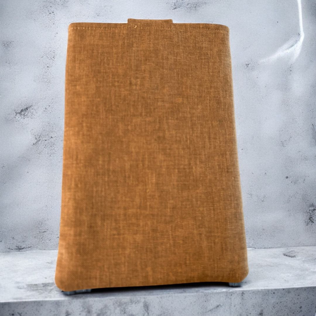 Back view of a taupe and ginger tablet sleeve made from textured repurposed fabric, displayed against a concrete background