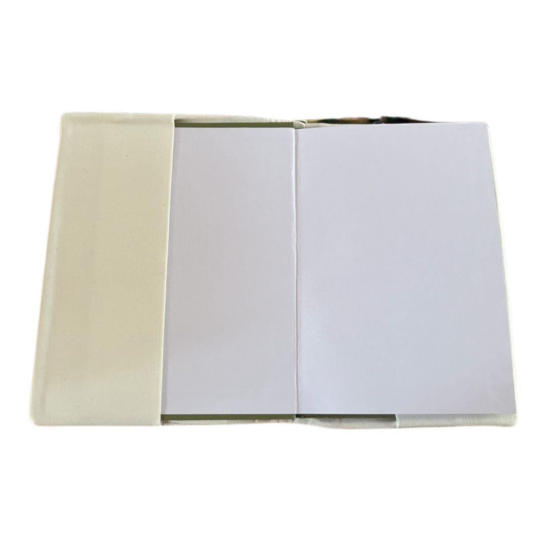 Interior view of an A5 fabric notebook cover with a hardback notebook inserted, showing cream quilted fabric lining and side flaps holding the notebook in place.