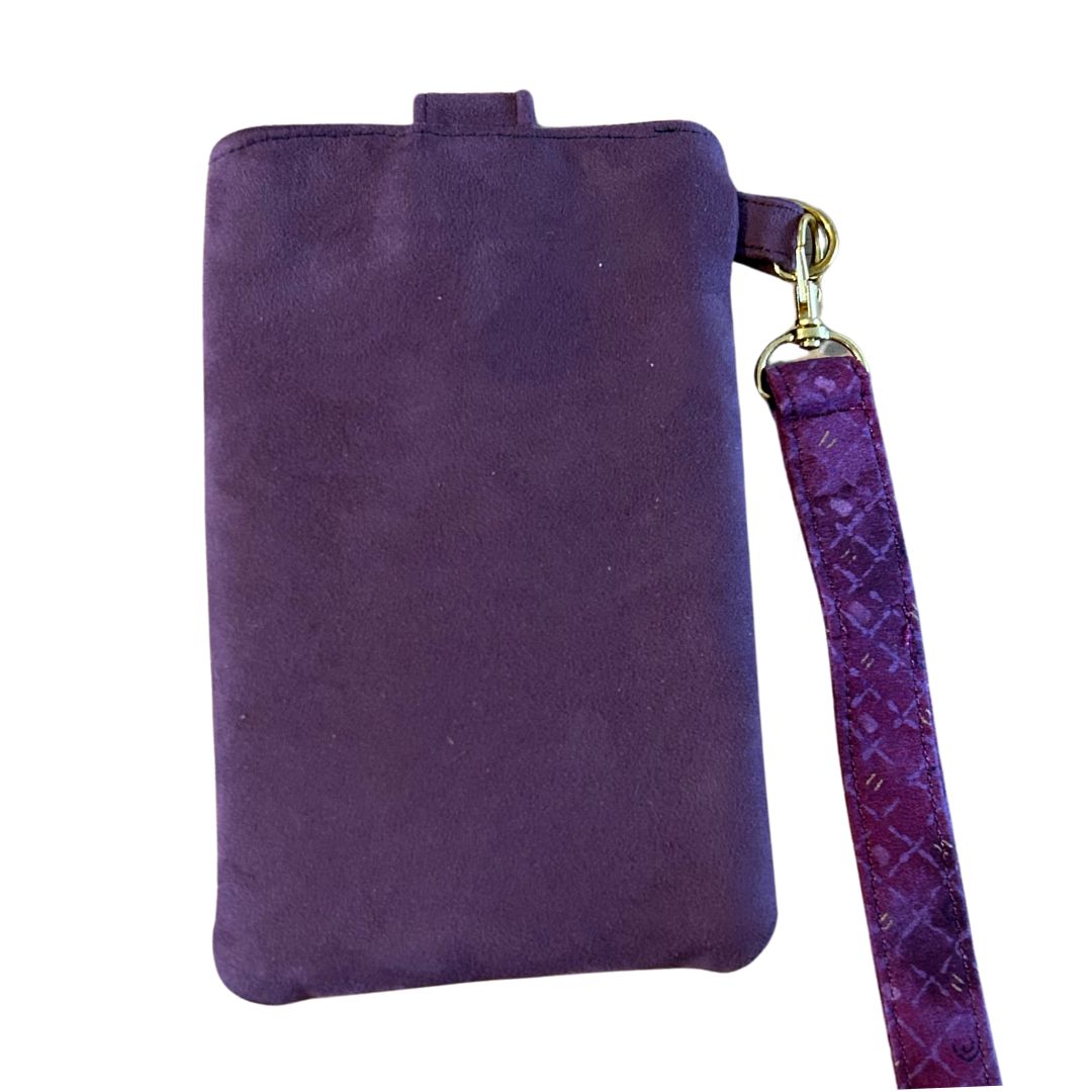 Back view of a purple faux suede phone case with a gold clip holding a matching detachable wristlet.