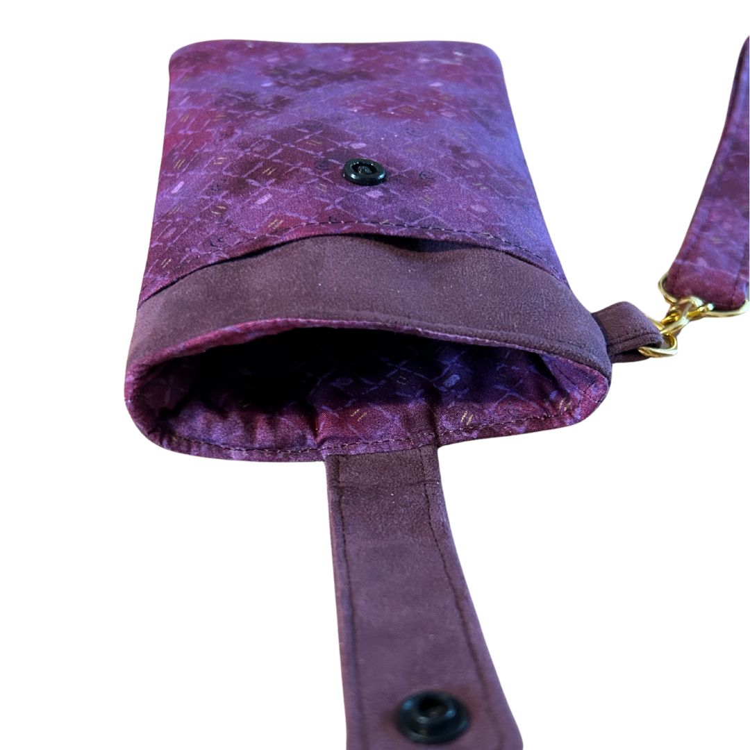 Open view of the purple phone case showing the cotton lining with a patterned print and front slip pocket.