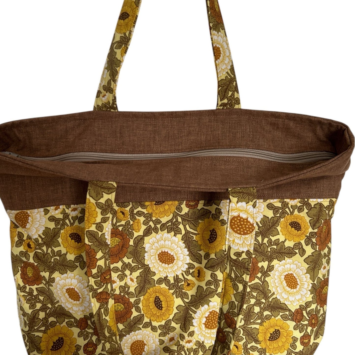 Brown tote bag with floral pattern on a white background with zip top