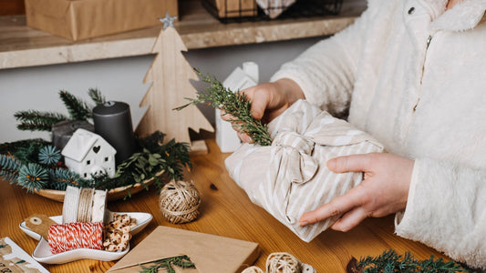 person wrapping gifts with eco friendly fabric and string