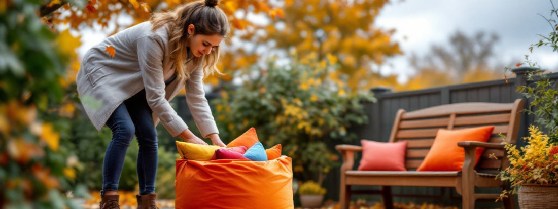 Woman packing colourful cushions into an outdoor storage bag in autumn, with fall foliage in the background and matching cushions on a wooden garden bench.