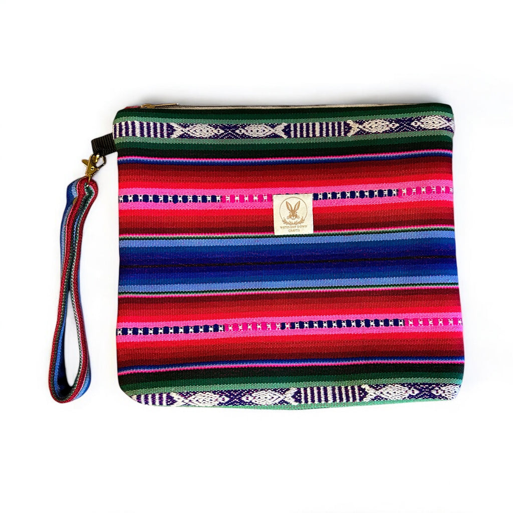 Handmade boho zipper pouch in vibrant pink, blue, and green woven patterns, featuring a detachable wristlet strap for added convenience. Perfect for organizing essentials or using as a standalone accessory.