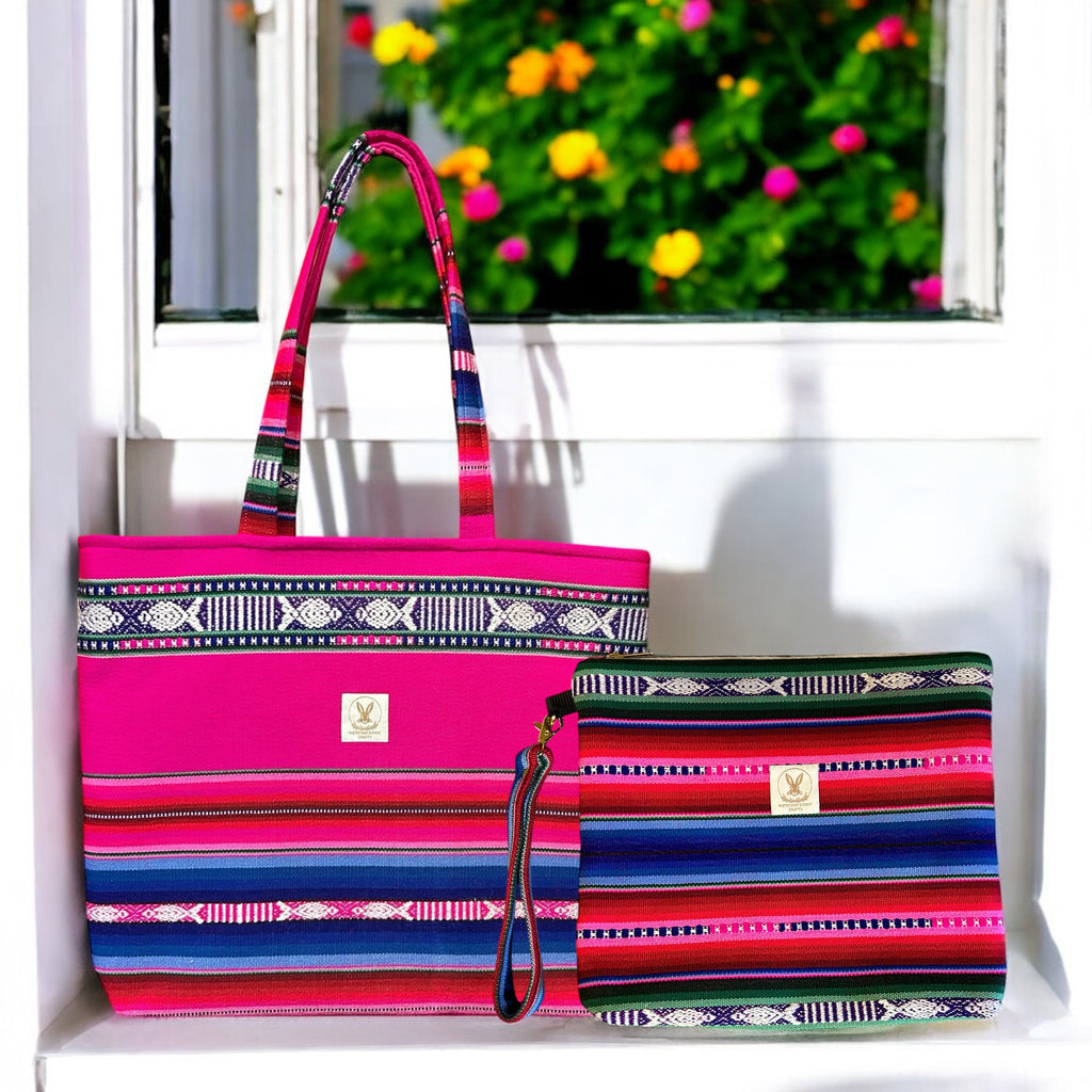 Handmade boho tote bag and matching zipper pouch set in vibrant pink, blue, and green woven patterns, displayed on a windowsill with colorful flowers in the background. Featuring a detachable wristlet strap and spacious design, this set combines style and functionality for everyday use.