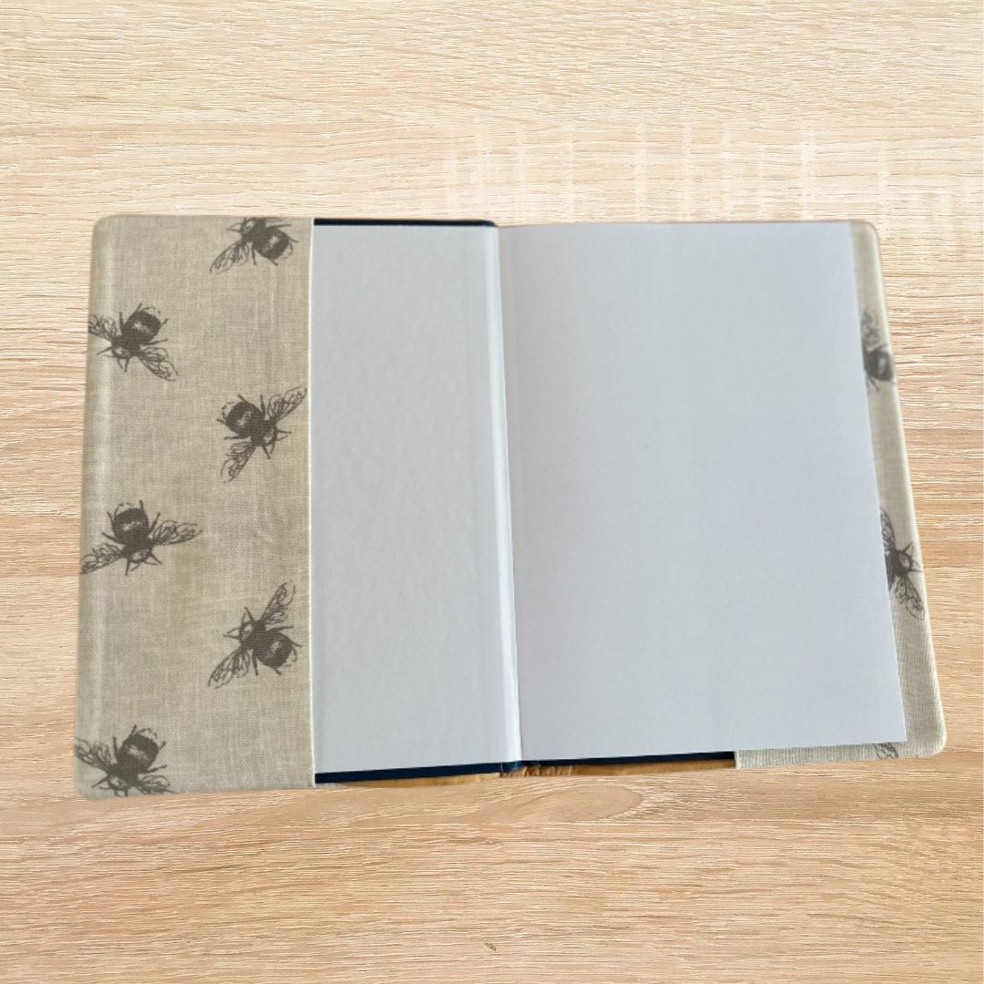 Interior view of the A5 notebook showing the lined hardback notebook inside the bee print fabric cover.