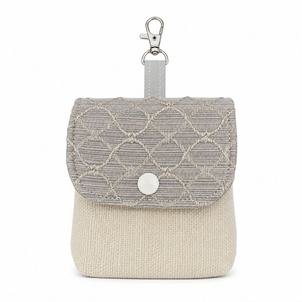 Small fabric pouch with a textured pattern and metal clasp on a white background