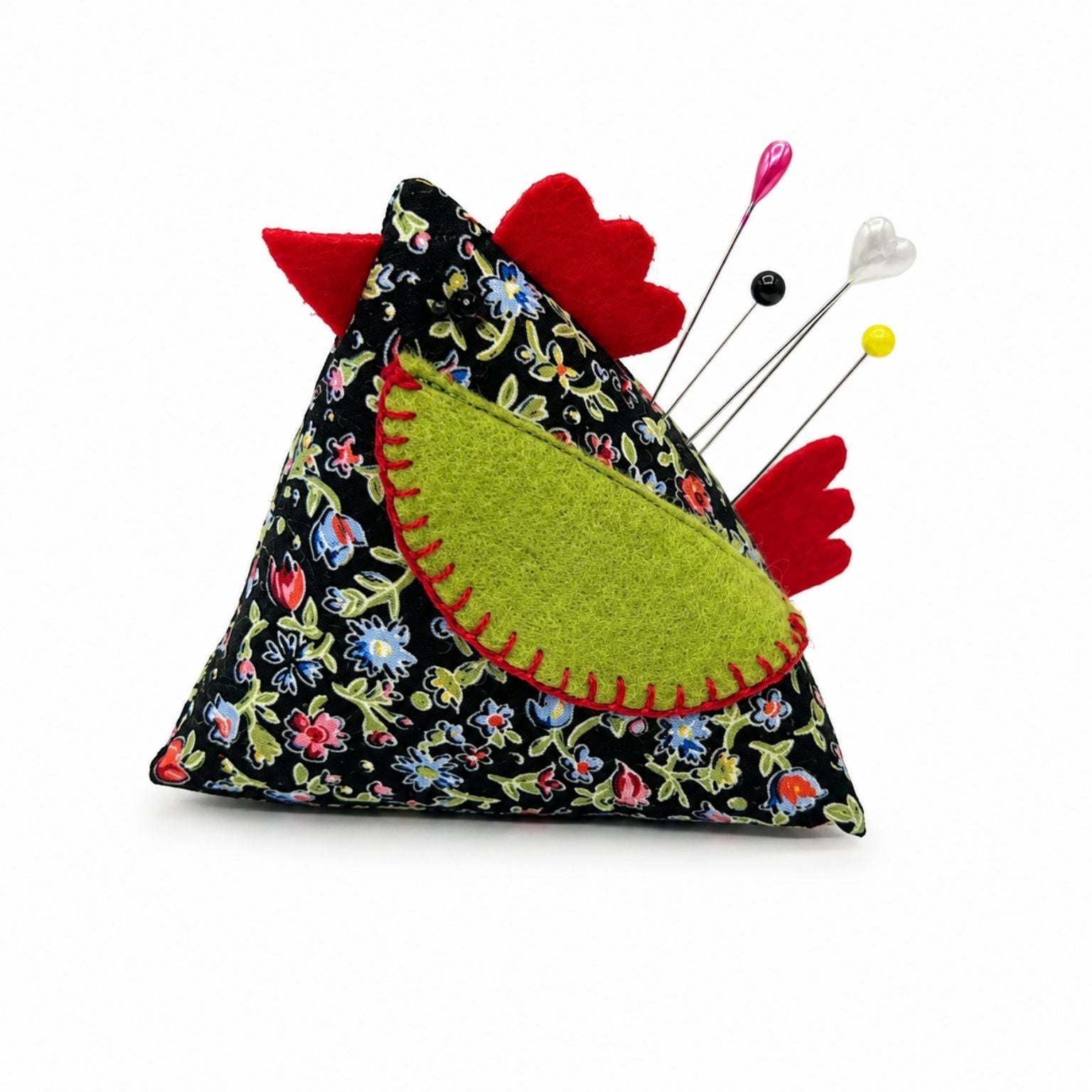 Chicken-shaped pincushion with colorful pins on a white background