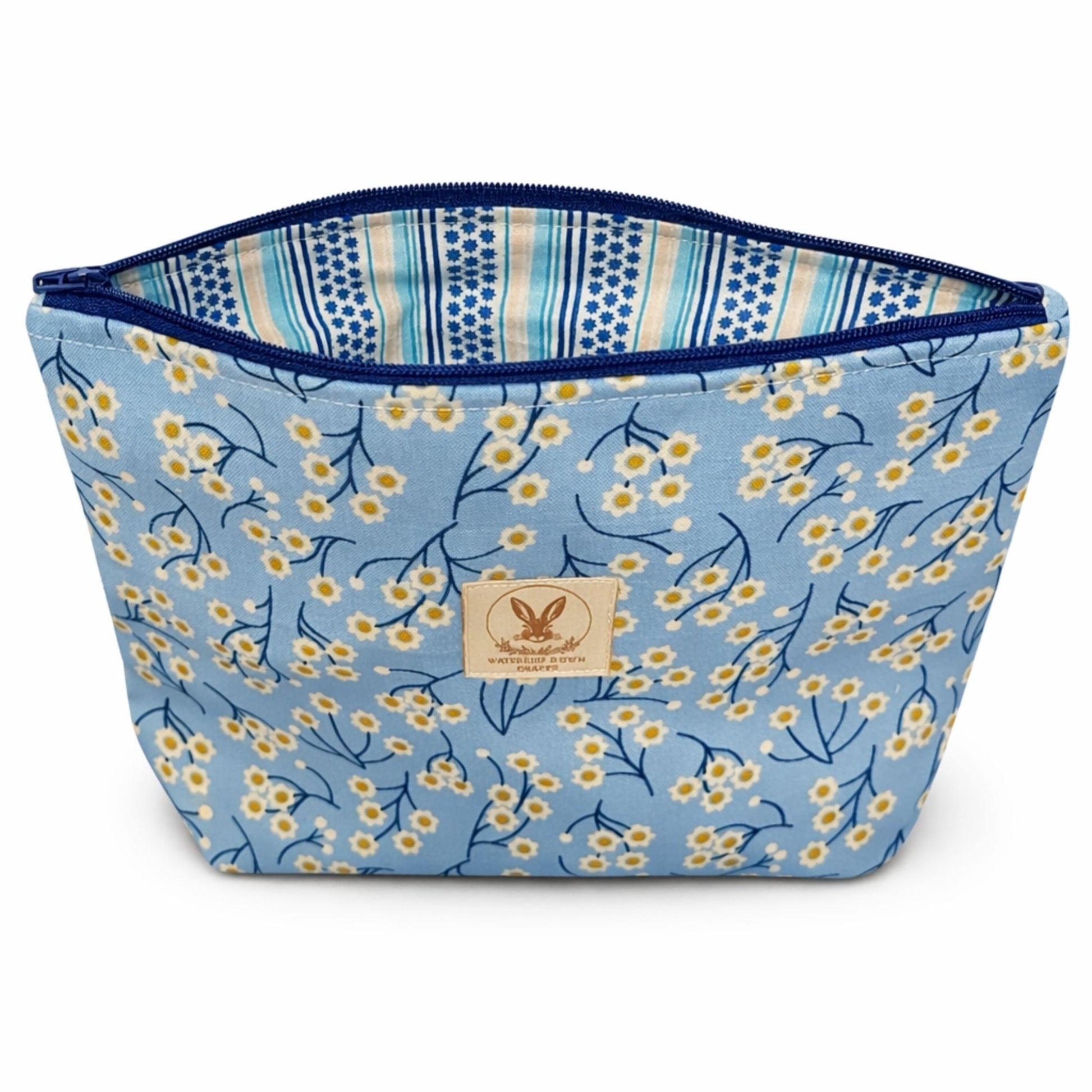 Floral-patterned fabric bag with a visible brand label on a white background