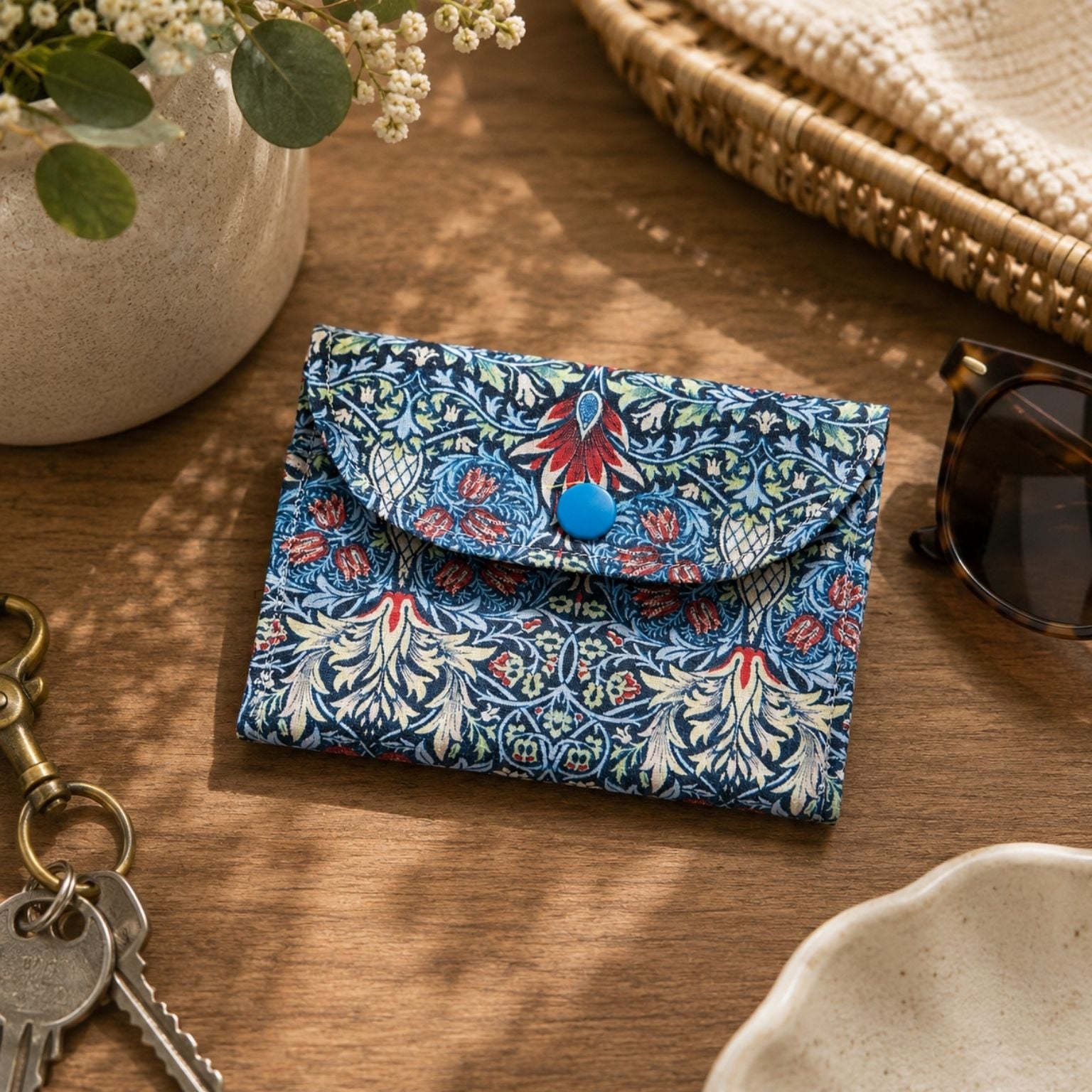 Blue Snakeshead Lily Cotton Card Walletwith a blue button on a wooden surface with keys and sunglasses.
