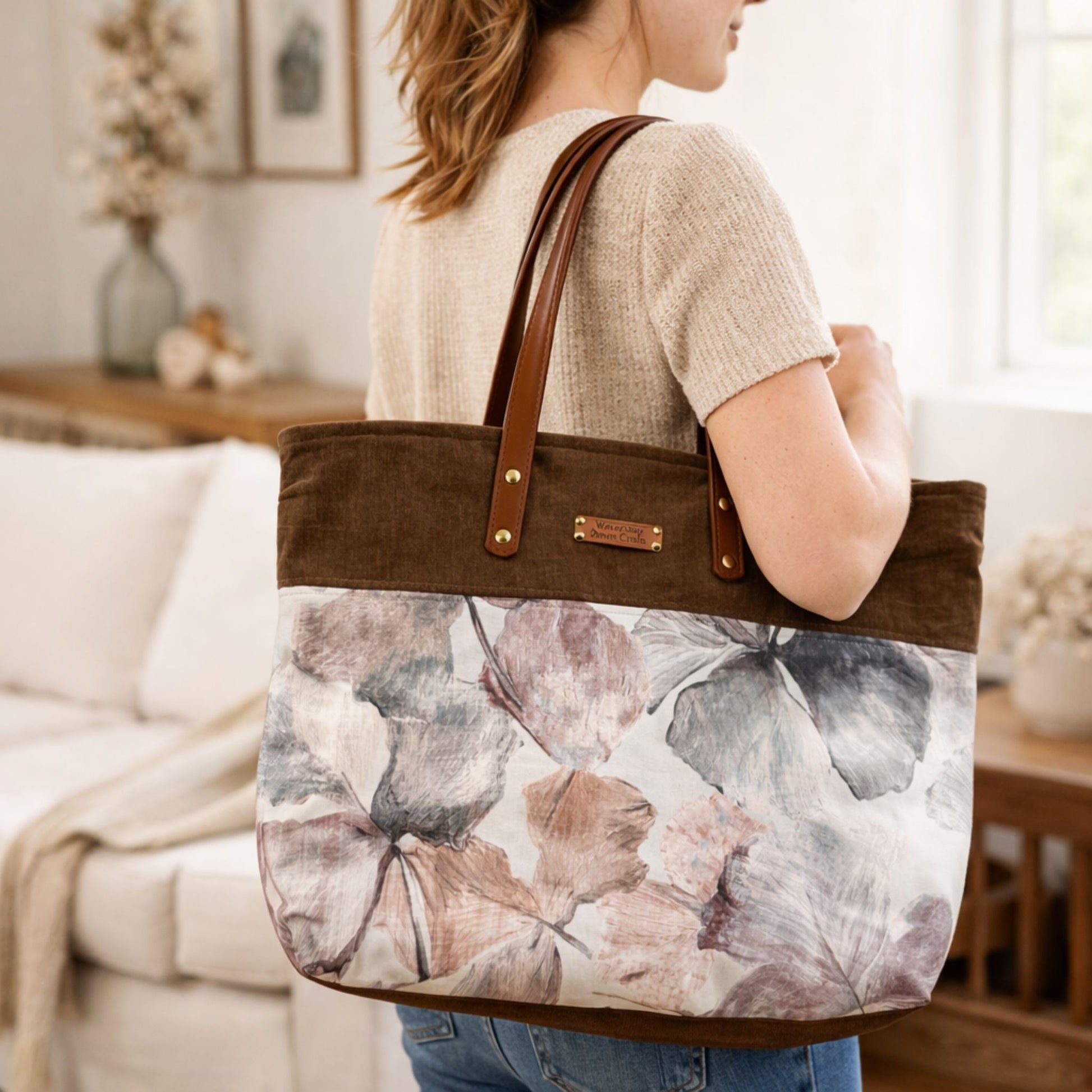 Person holding a floral tote bag in a living room setting