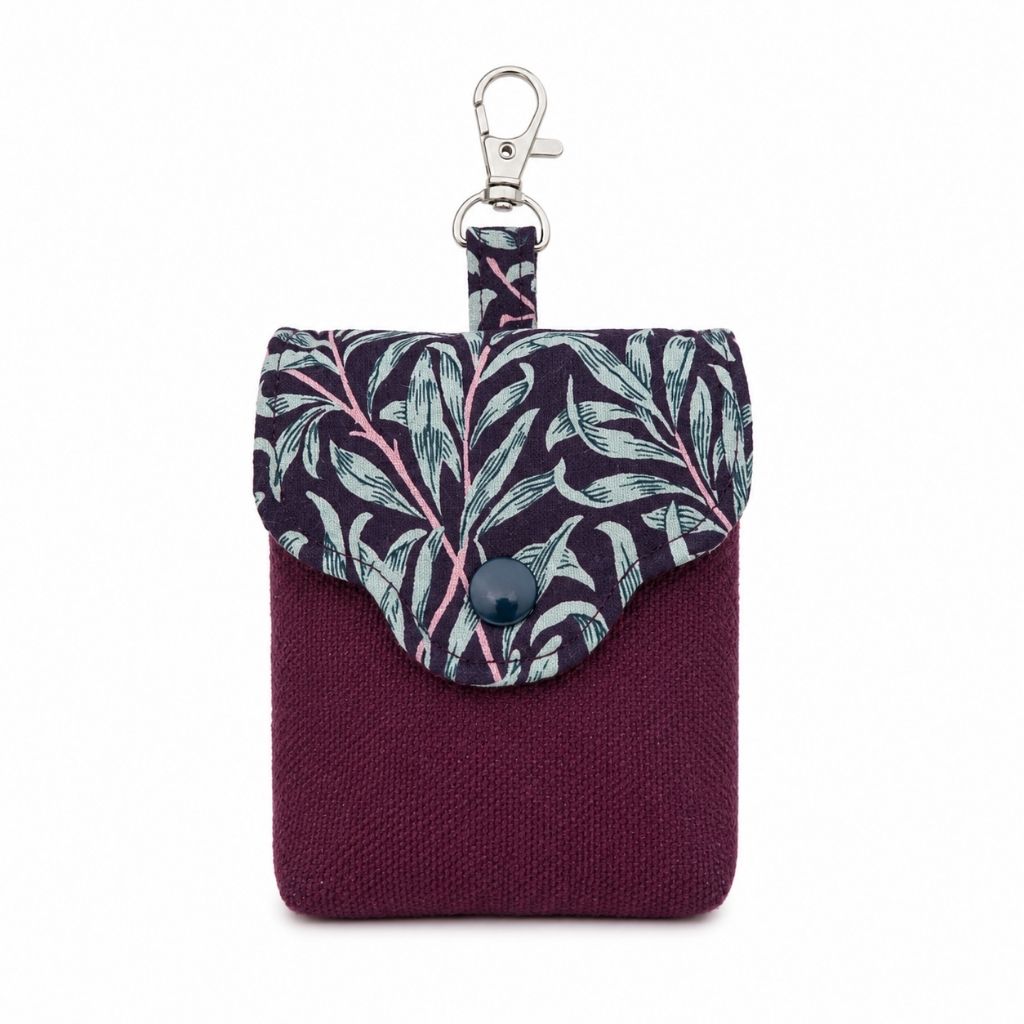 Small pouch with leaf pattern and keychain on a white background
