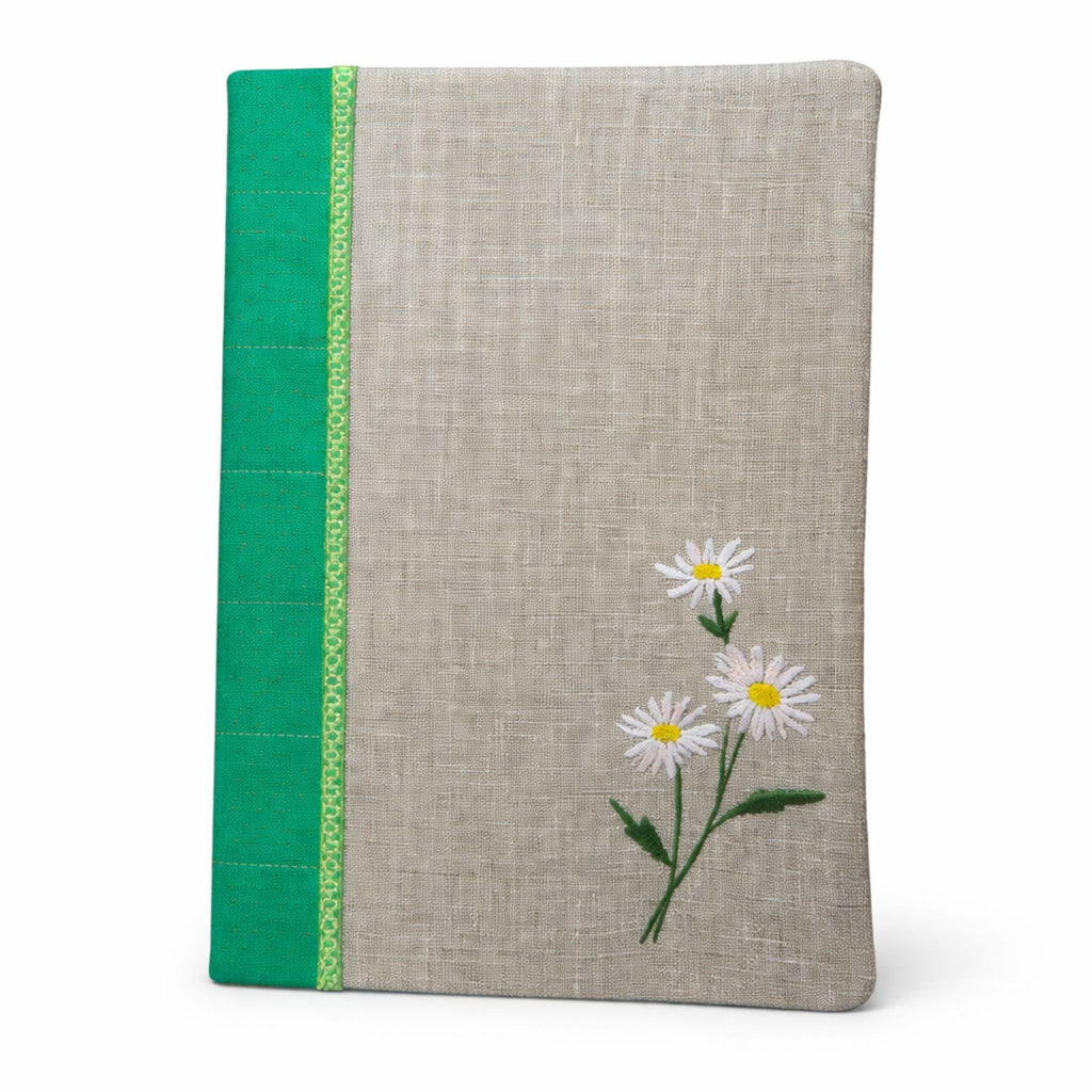 Notebook with floral design and green accent on a white background