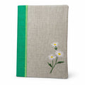 Notebook with floral design and green accent on a white background