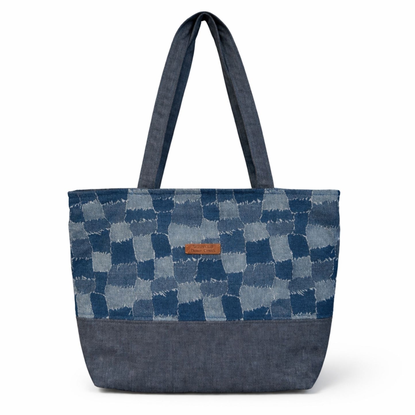 Blue patchwork tote bag with a visible brand label on a white background