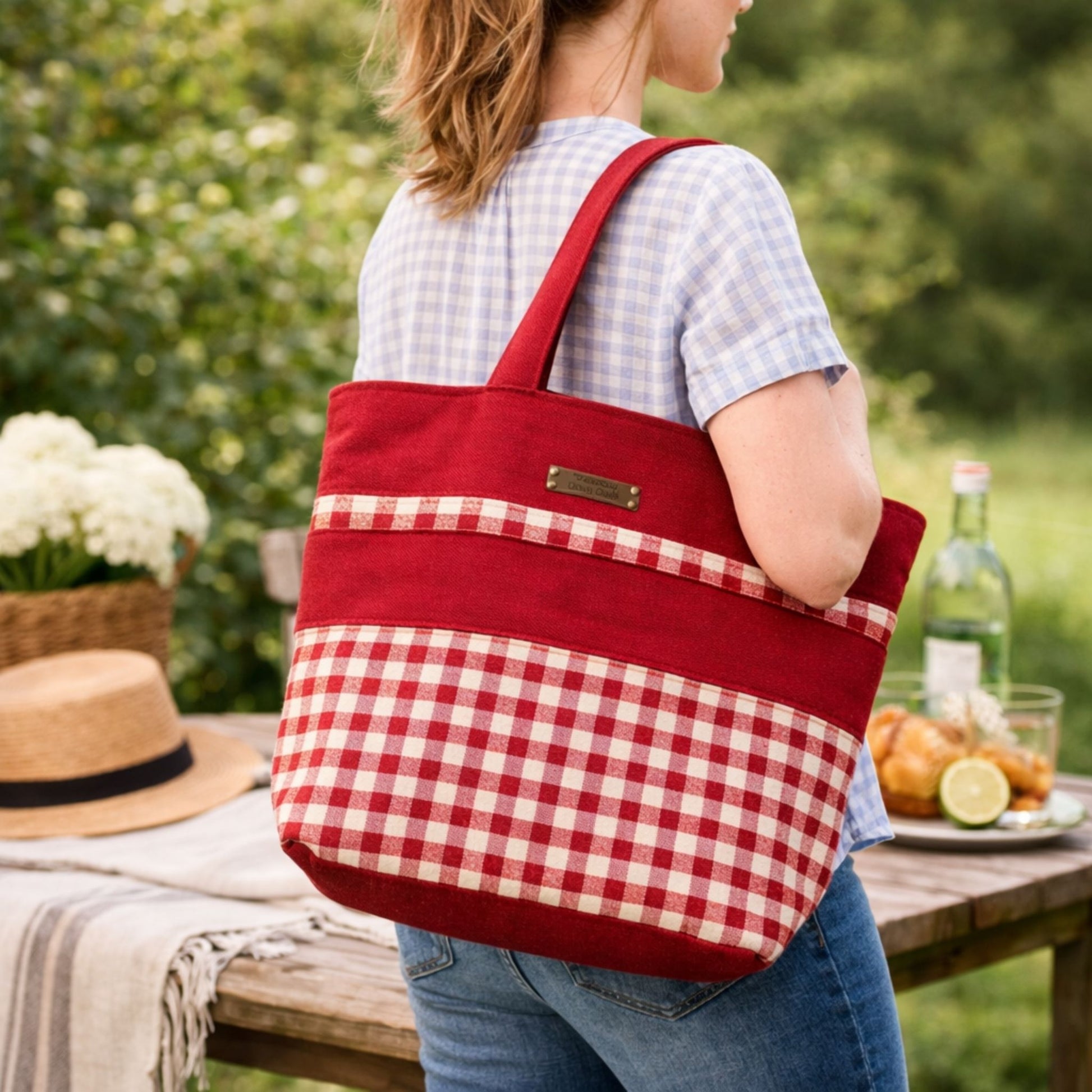 Person holding a red and white checkered tote bag outdoors