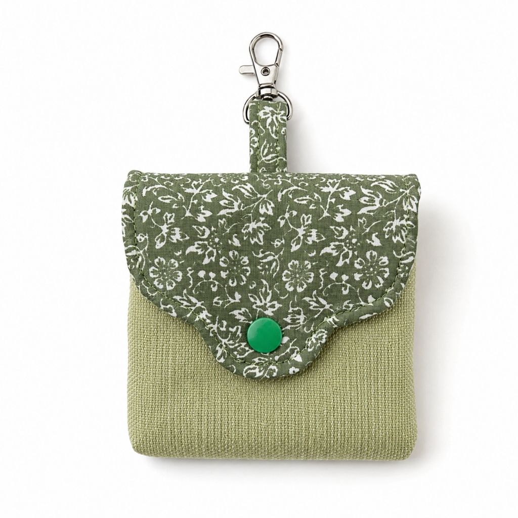 Green fabric pouch with floral pattern and green button on a white background