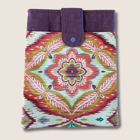 Boho tablet sleeve with a red, green, and plum mandala print, plum contrast panel, and snap closure, made from repurposed fabric