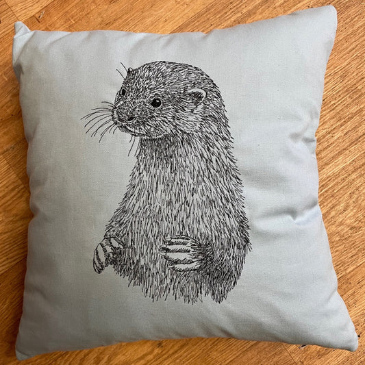 Pale blue handmade cushion with embroidered sketch of and otter