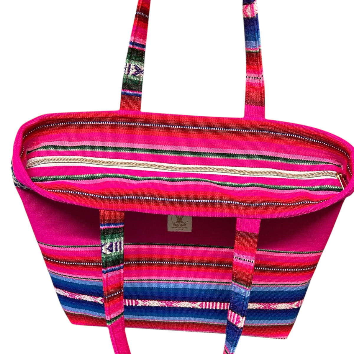 Top view of a handmade boho tote bag showcasing its vibrant pink, blue, and green woven fabric and secure inset zip-top closure. The spacious interior and bold design make it both functional and stylish for everyday use.