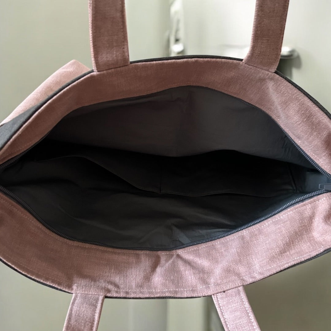 Open tote bag showing a spacious interior with multiple pockets and a zip closure.