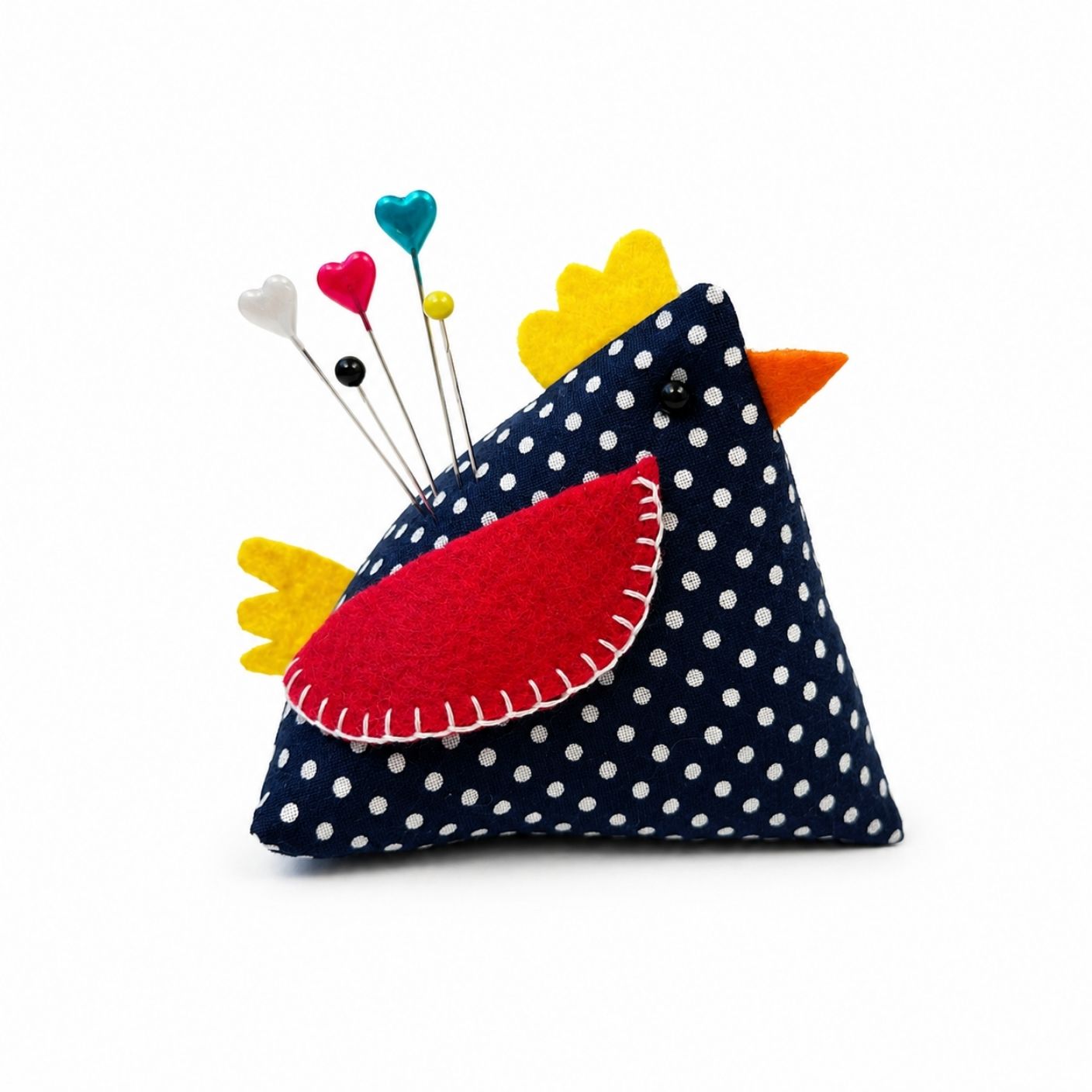 Polka dot pin cushion with colorful bird design on a white background