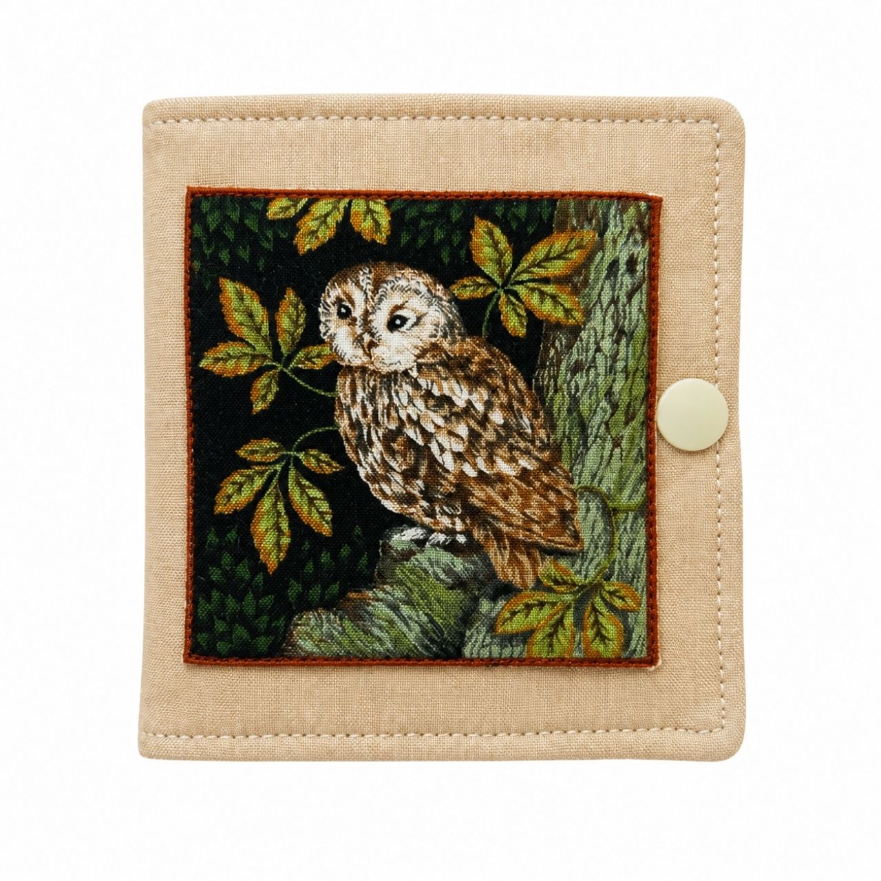 Small needle case with an owl design on a beige background
