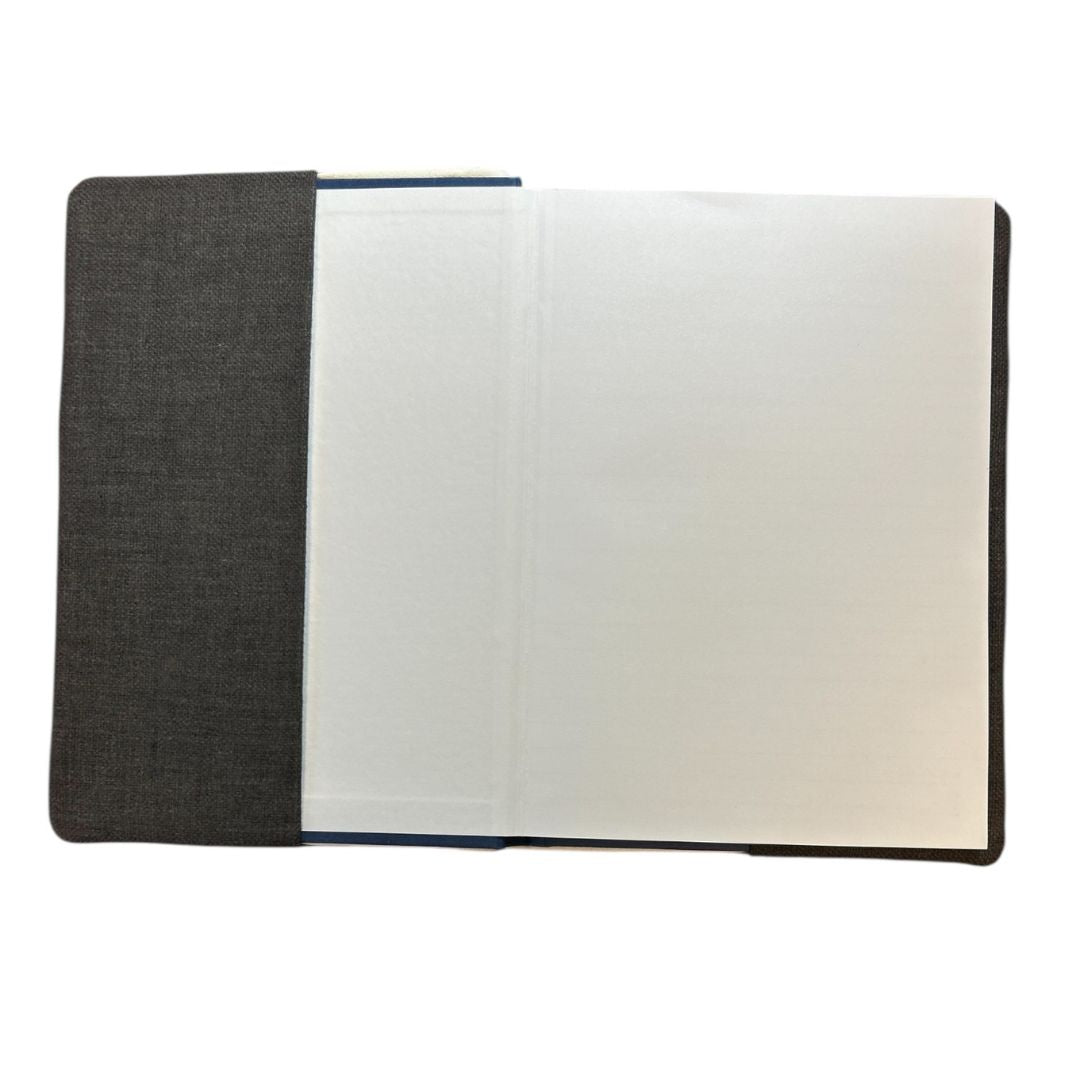 Interior view of a handmade notebook cover in dark fabric, showing a lined notebook securely held inside with neat stitched edges.