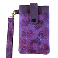 Front view of the purple faux suede phone case with a patterned flap, snap closure, and matching wristlet attached.