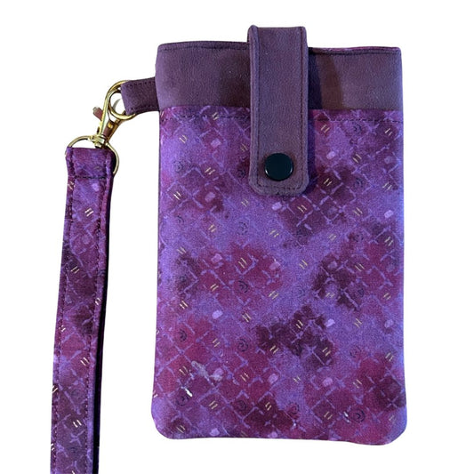 Front view of the purple faux suede phone case with a patterned flap, snap closure, and matching wristlet attached.