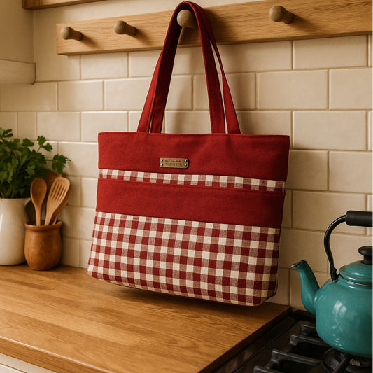 Red and white checkered tote bag hanging on a wooden hook against a tiled wall.