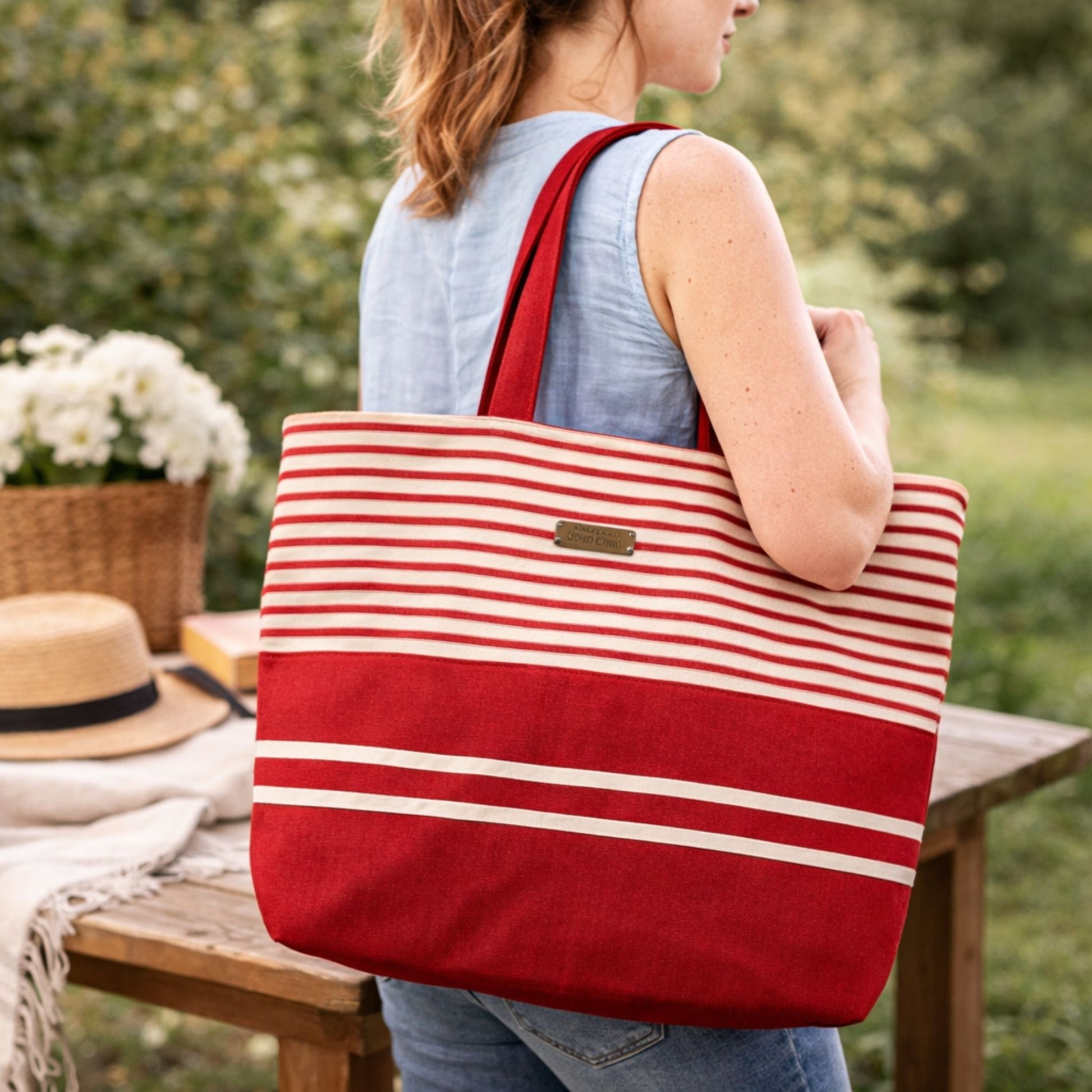 Person holding a red and white striped tote bag outdoors