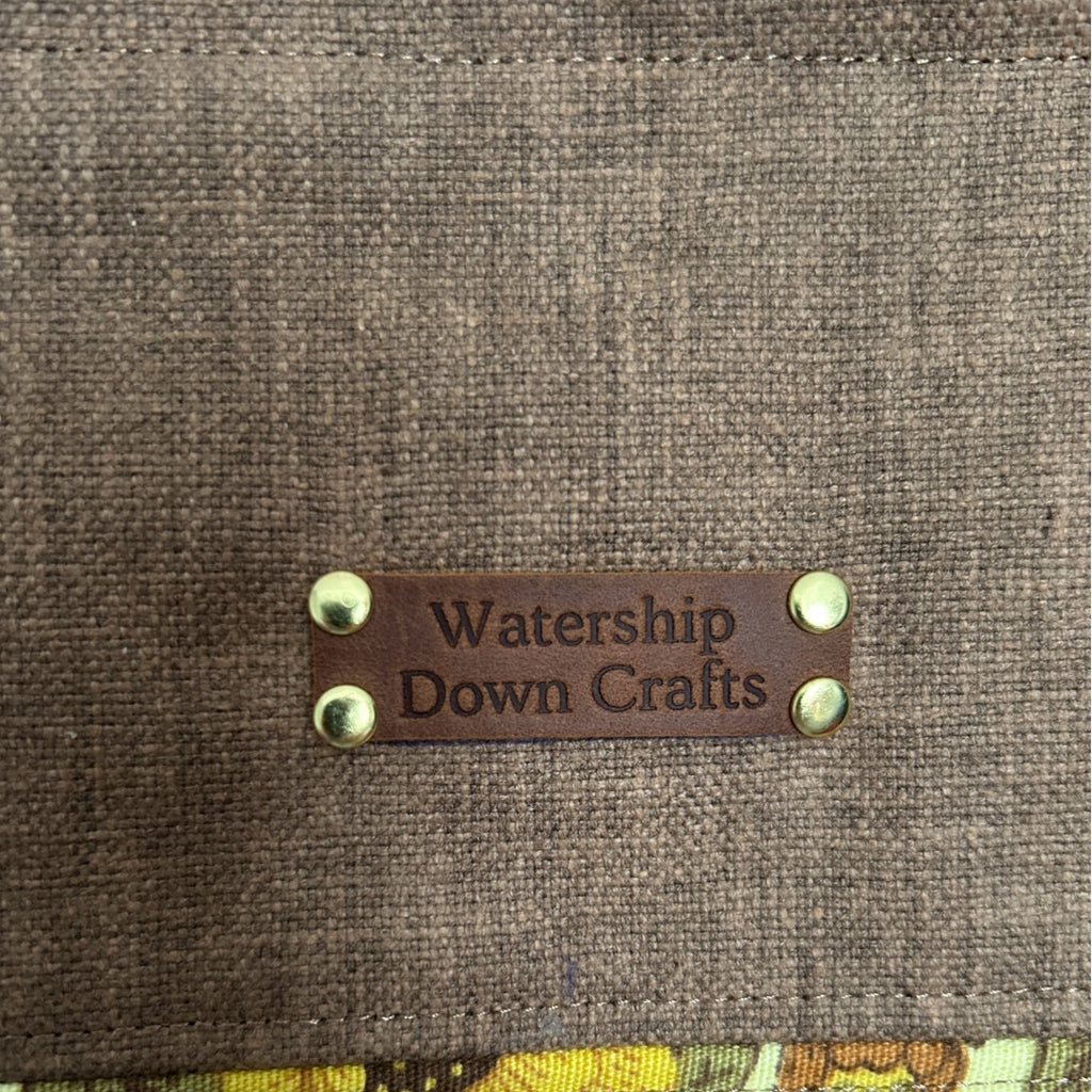 Brown fabric surface with a leather label reading 'Watership Down Crafts'.