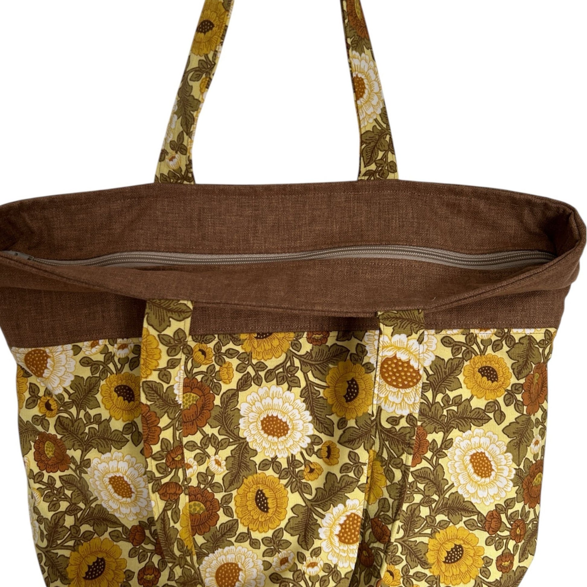 Brown tote bag with floral pattern on a white background with zip top