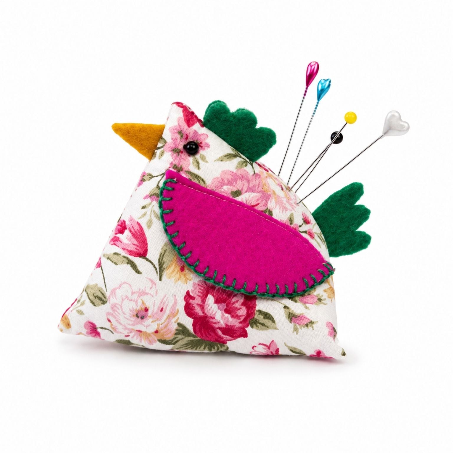 Floral-patterned bird-shaped pincushion with pins on a white background