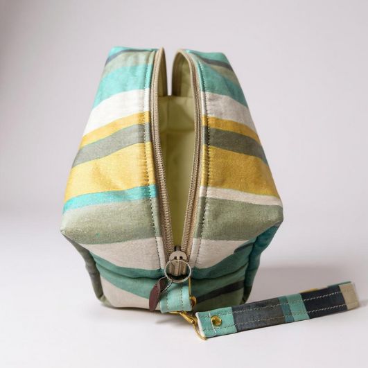 Top-down view of the pouch with zip open, showing pale yellow water-resistant lining and spacious interior.