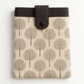 Beige and dark grey tree print tablet case with snap closure and front pocket, made from repurposed fabric