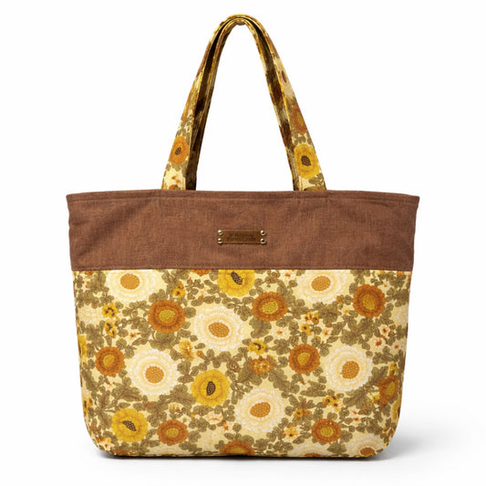 Floral patterned tote bag with brown top section on a white background
