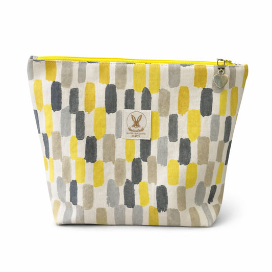 Fabric pouch with geometric pattern and visible brand logo on a white background